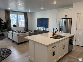 12 South Moonlit Road Mapleton, UT 84664 - Photo 13 of 14 Kitchen featuring open floor plan, white cabinets, stainless steel appliances, an island with sink, and wood finished floors