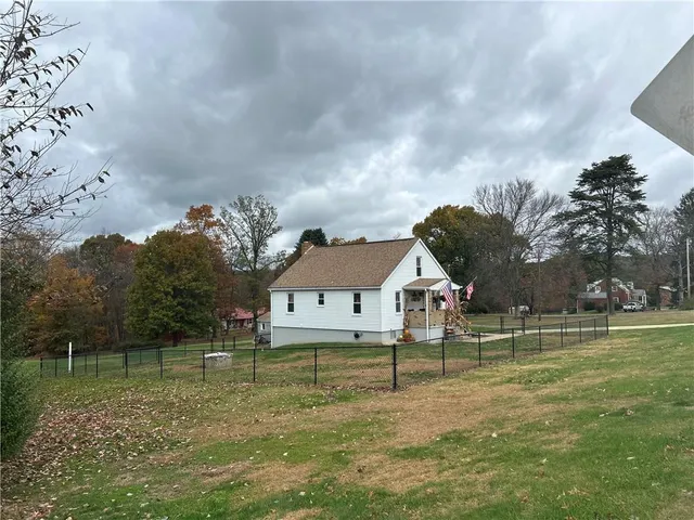 a view of a house with backyard and fence