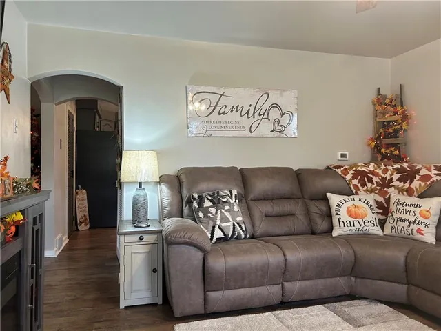 a view of a hallway to a livingroom with furniture and windows