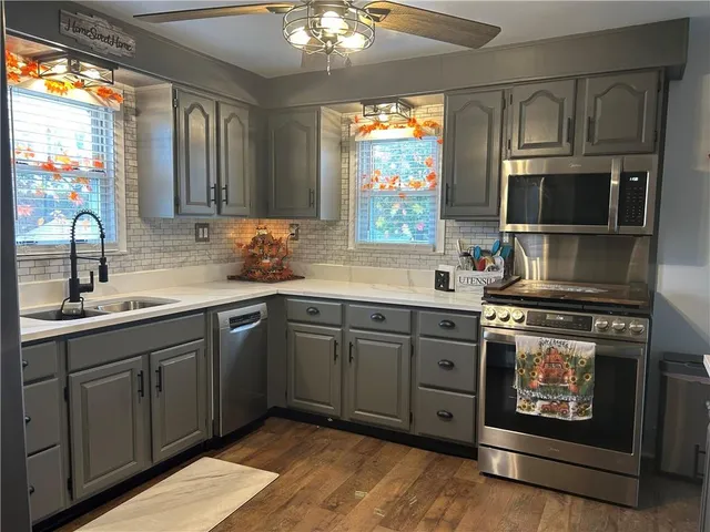 a kitchen with stainless steel appliances granite countertop a refrigerator and a sink