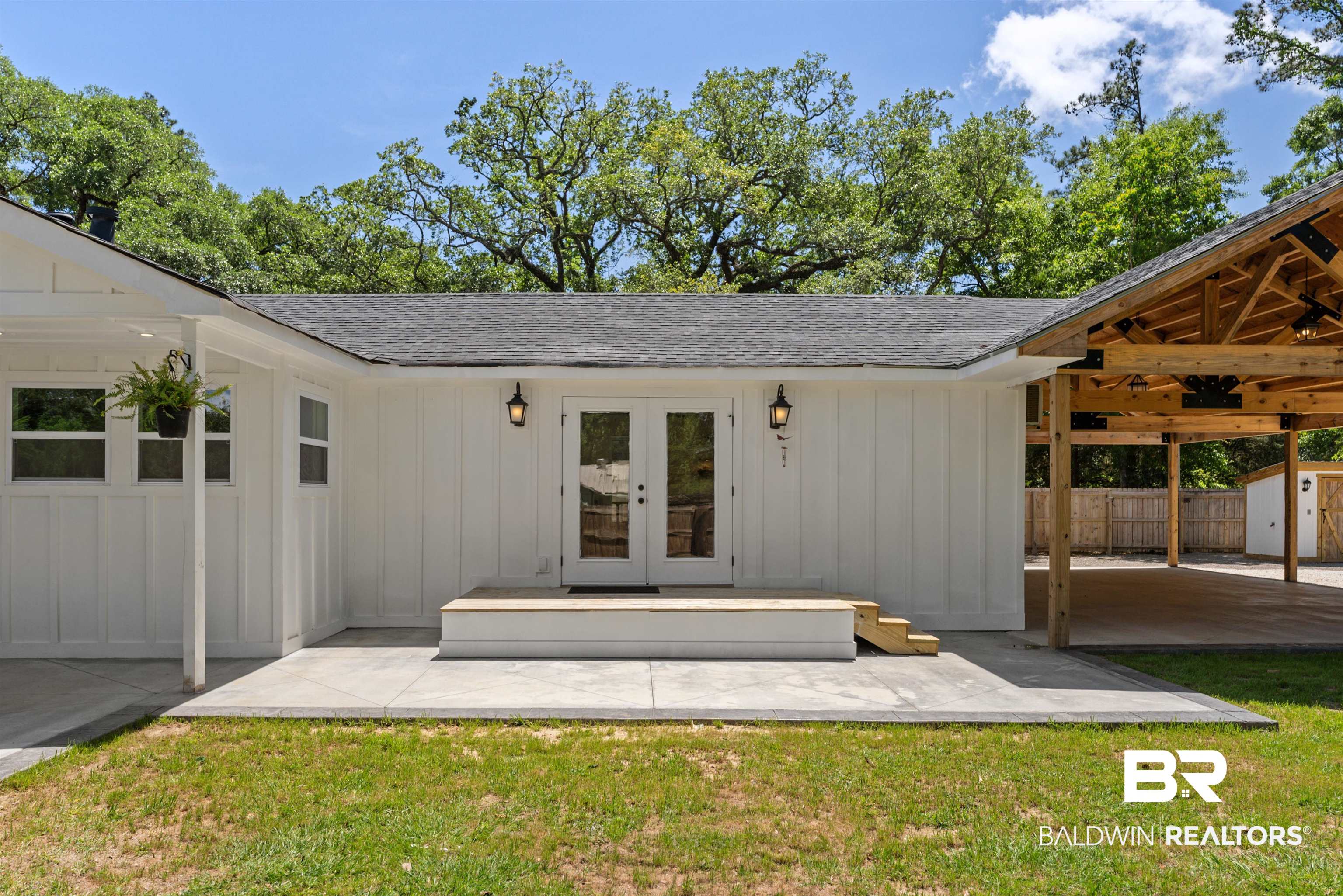 6447 Bemis Lane Bon Secour, AL 36511 - Photo 9 of 62 White board and batten exterior with a dark shingle roof and a concrete patio