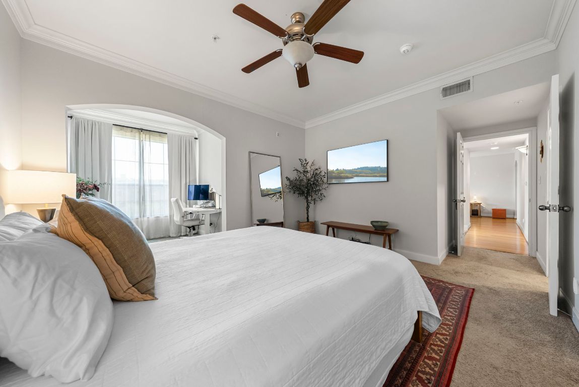 7701 Rialto Boulevard, Unit 1426 Austin, TX 78735 - Photo 12 of 29 a bed room with a bed and a chandelier