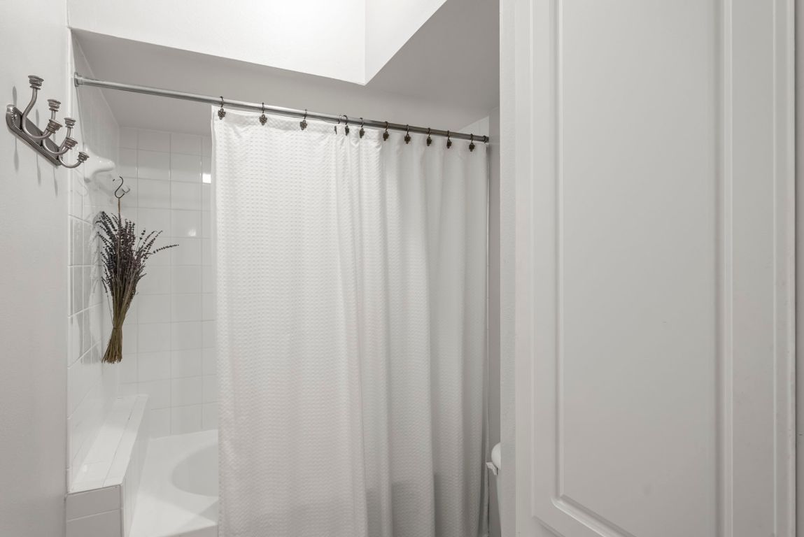 7701 Rialto Boulevard, Unit 1426 Austin, TX 78735 - Photo 14 of 29 a bathroom with a shower curtain and a shower curtain