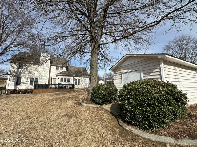 a view of a yard with plants and trees