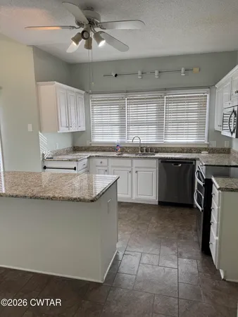 a large kitchen with a sink and cabinets