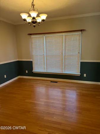 a view of a room with wooden floor and window
