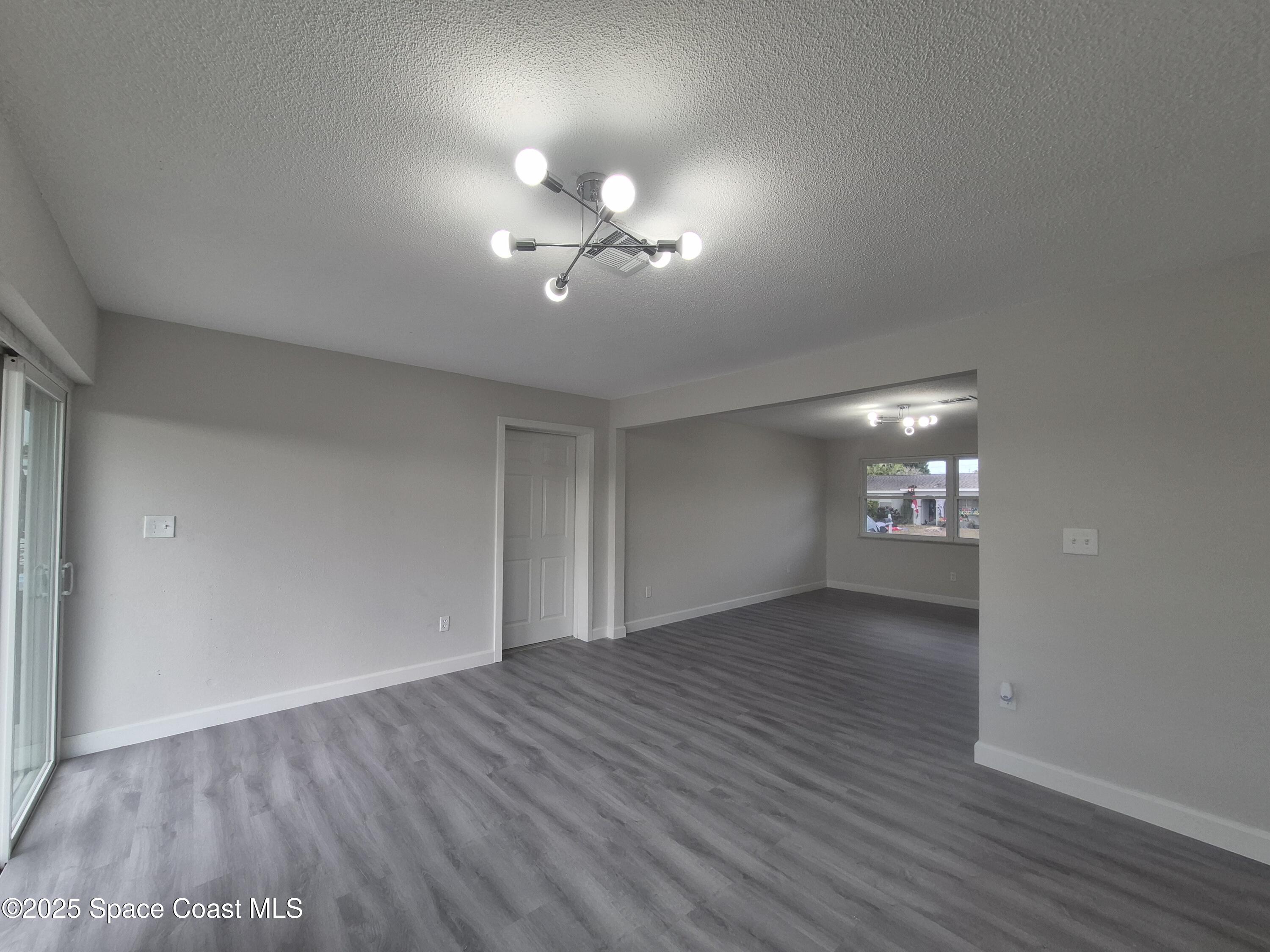980 Bacon Circle Northeast Palm Bay, FL 32905 - Photo 12 of 50 a view of empty room with wooden floor and fan
