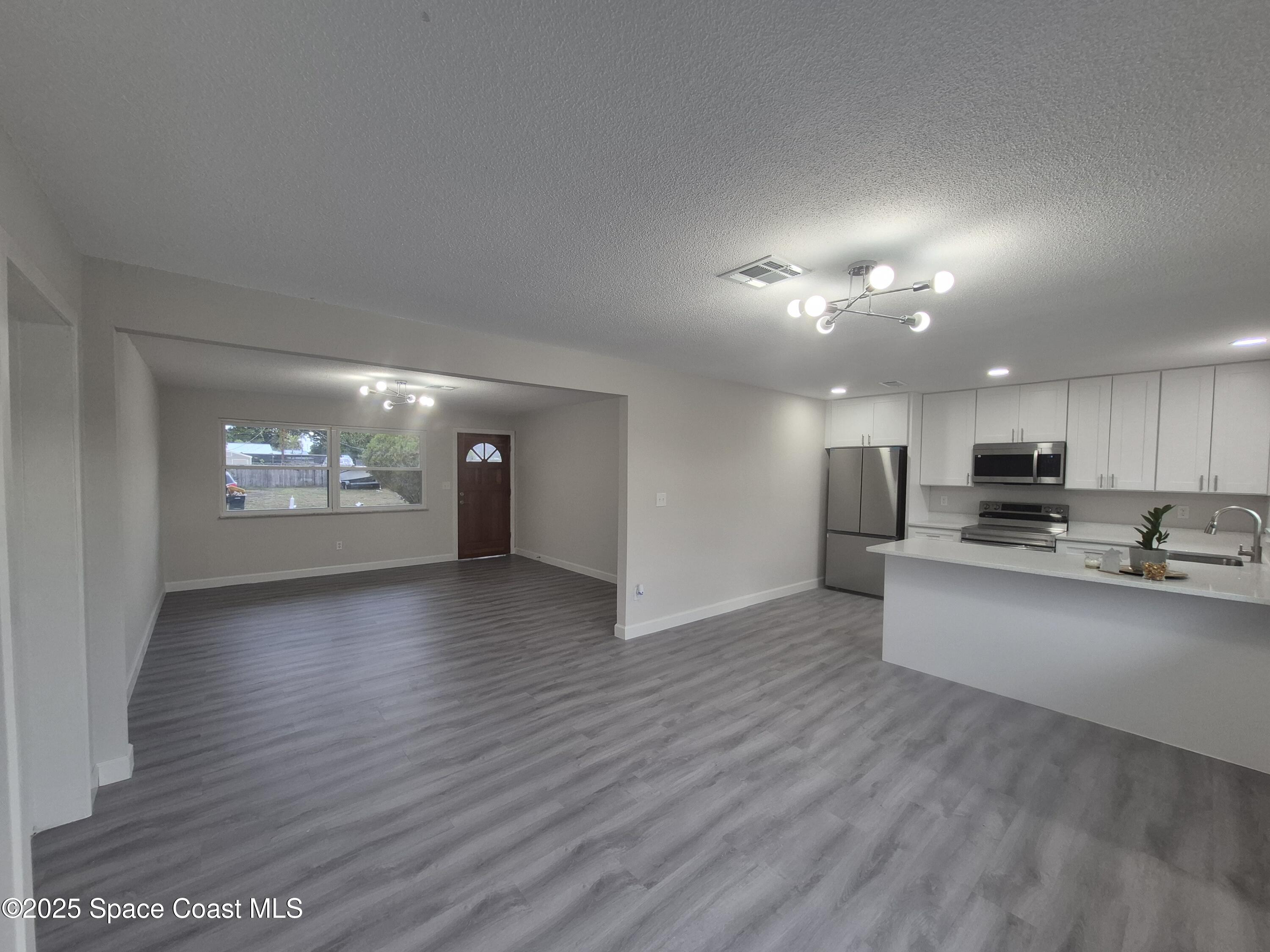 980 Bacon Circle Northeast Palm Bay, FL 32905 - Photo 21 of 50 a view of a kitchen with a sink and a stove top oven