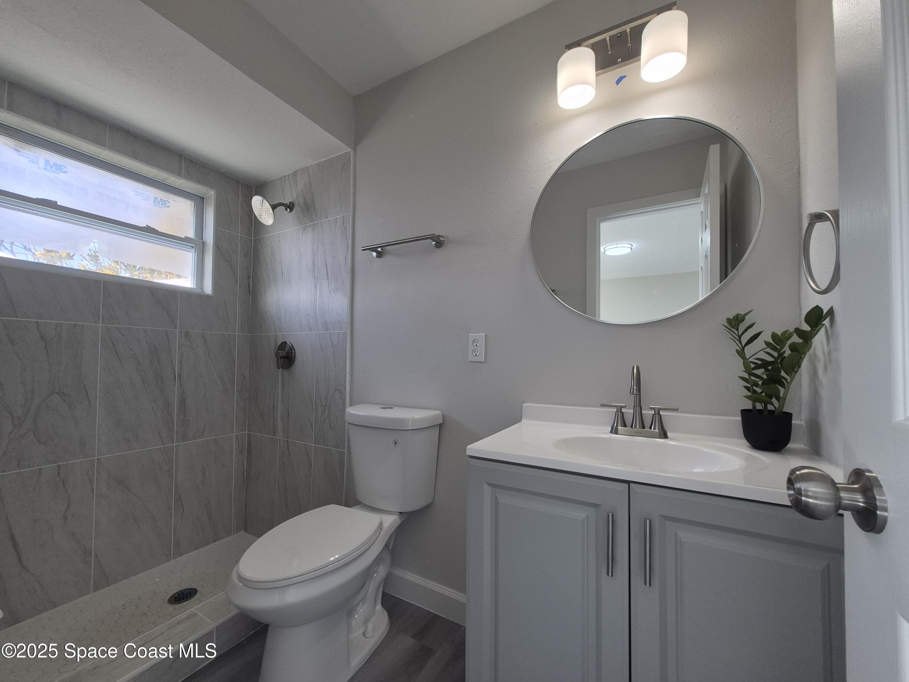 980 Bacon Circle Northeast Palm Bay, FL 32905 - Photo 26 of 50 a bathroom with a sink toilet and shower