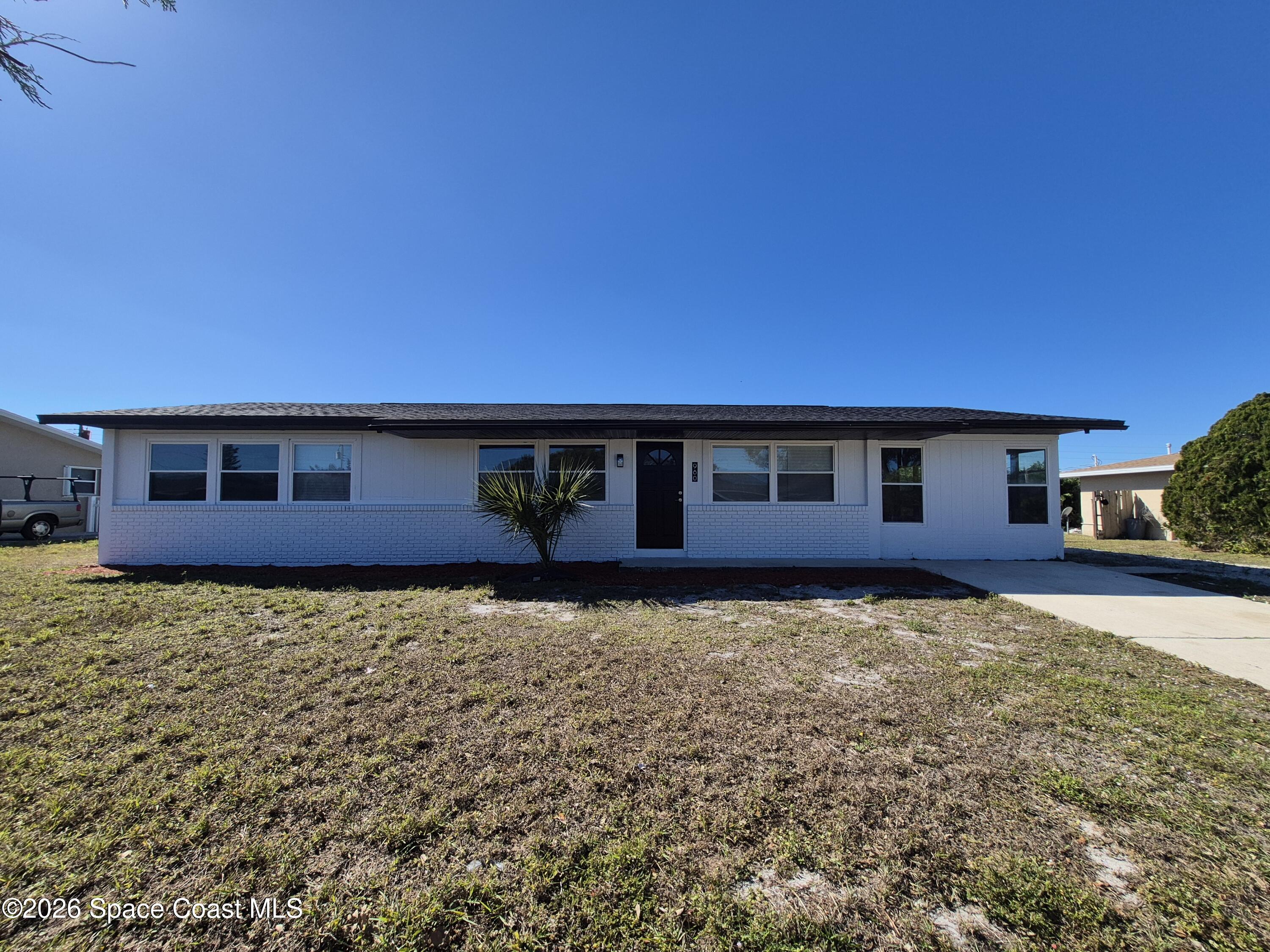 980 Bacon Circle Northeast Palm Bay, FL 32905 - Photo 3 of 50 a front view of a house with a yard