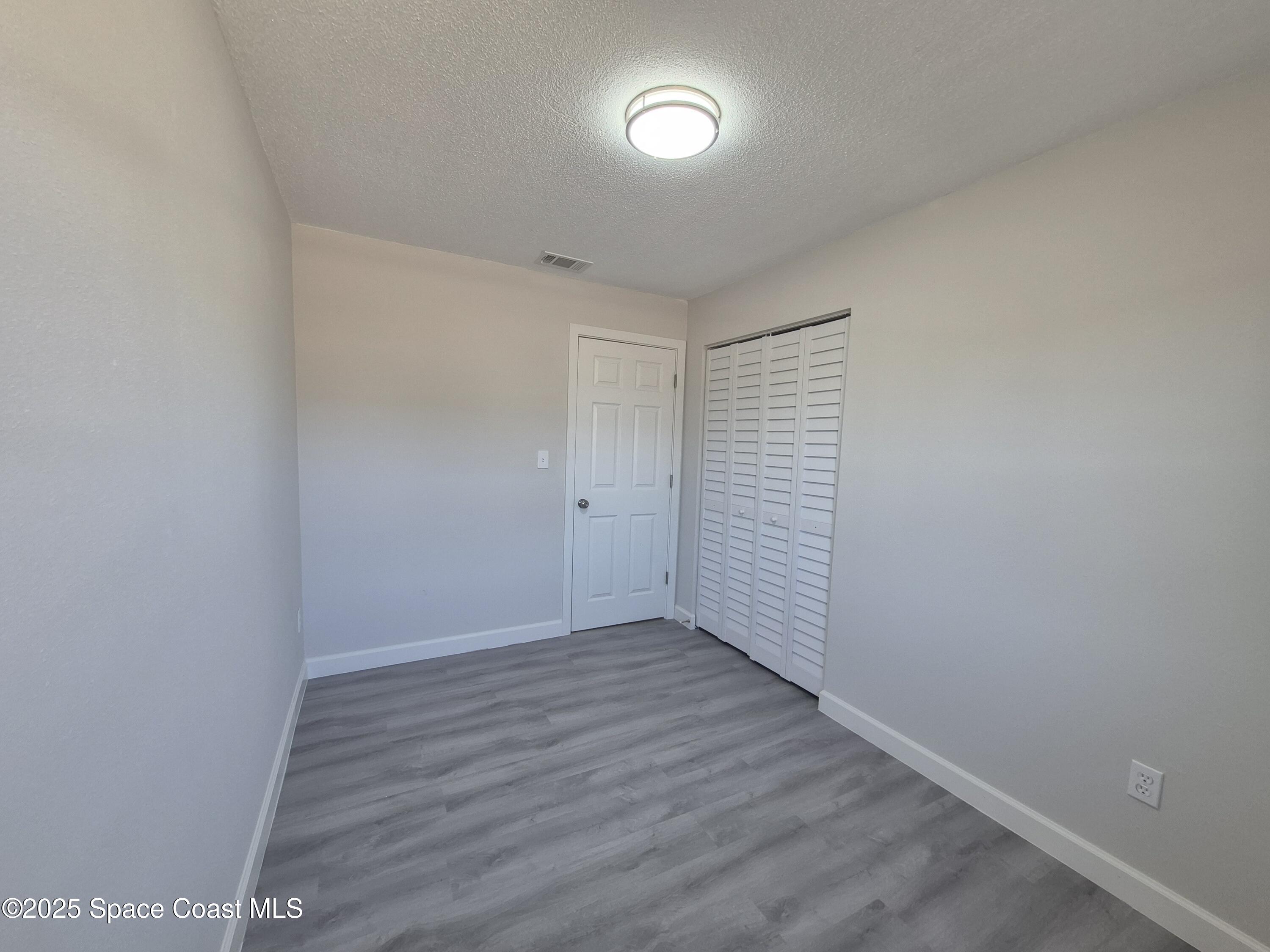 980 Bacon Circle Northeast Palm Bay, FL 32905 - Photo 31 of 50 a view of an empty room with wooden floor