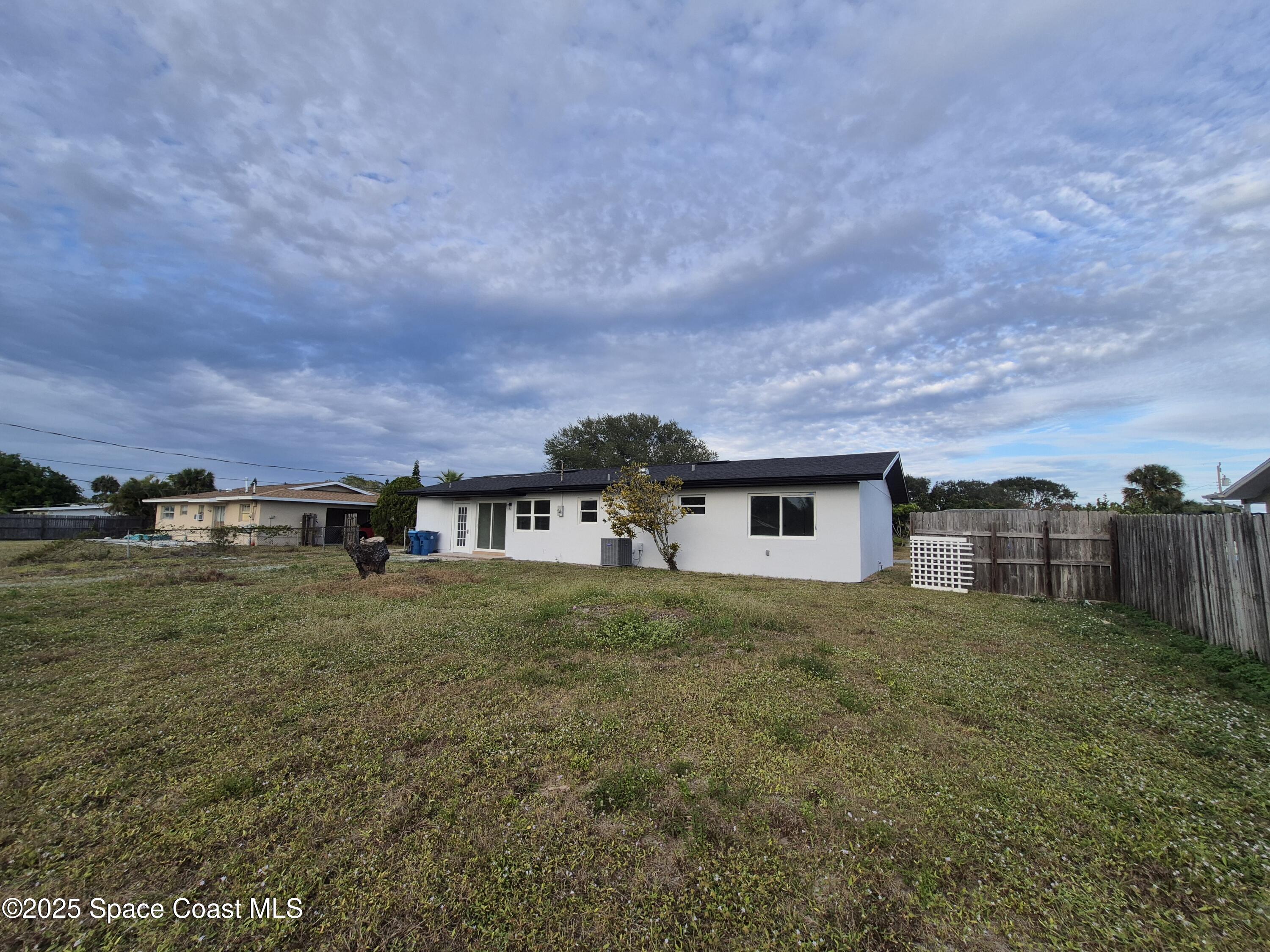 980 Bacon Circle Northeast Palm Bay, FL 32905 - Photo 50 of 50 a view of a house with a yard and large trees
