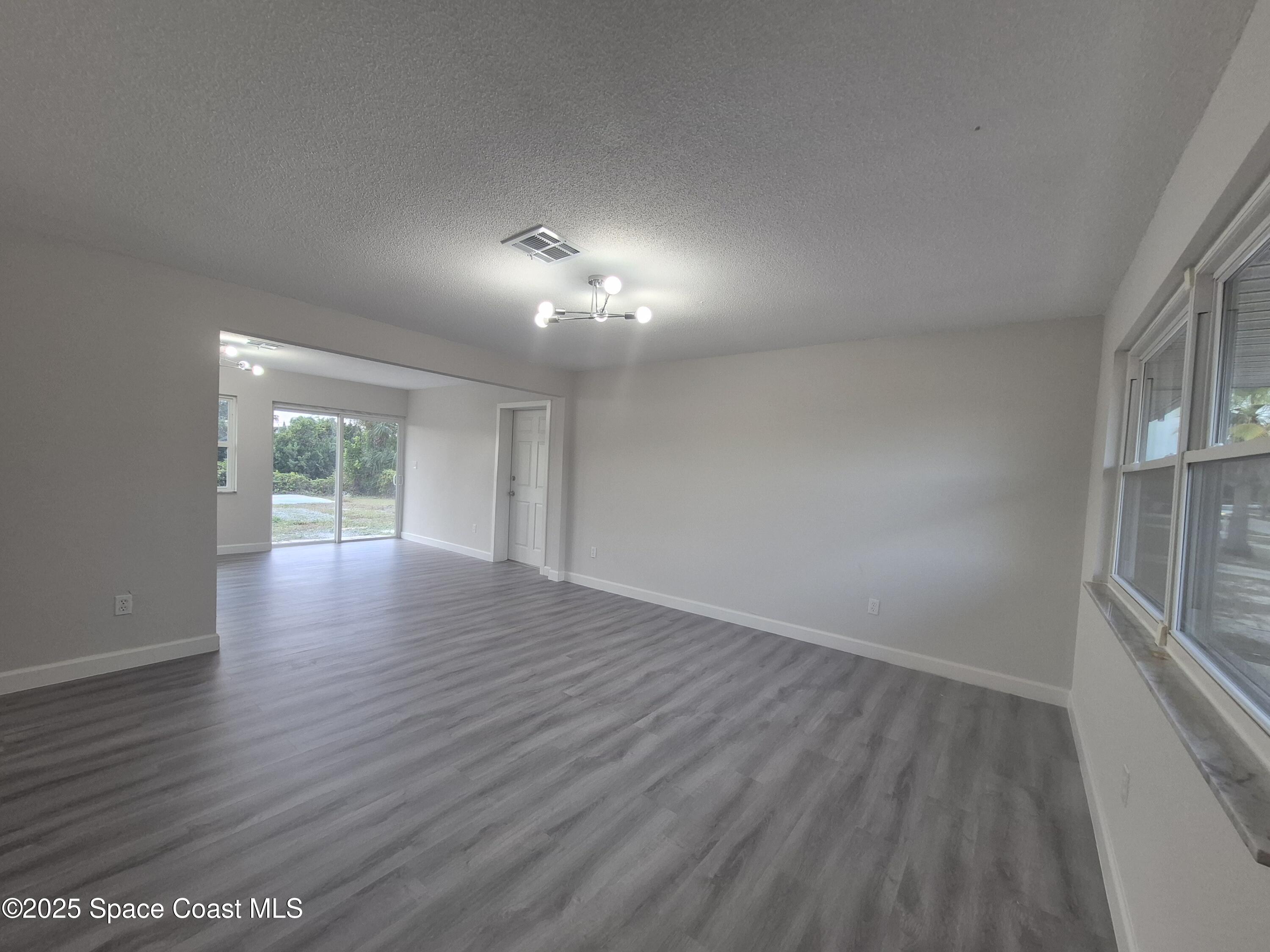 980 Bacon Circle Northeast Palm Bay, FL 32905 - Photo 8 of 50 wooden floor in an empty room with a window