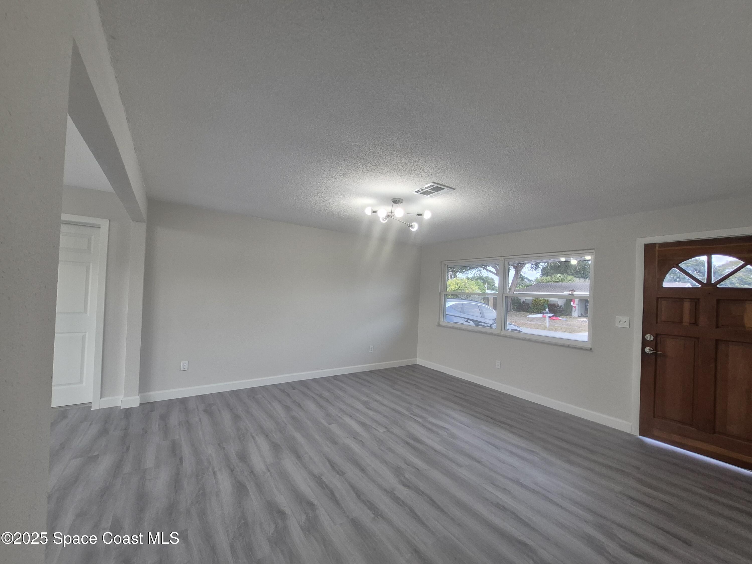 980 Bacon Circle Northeast Palm Bay, FL 32905 - Photo 10 of 50 wooden floor in an empty room with a window