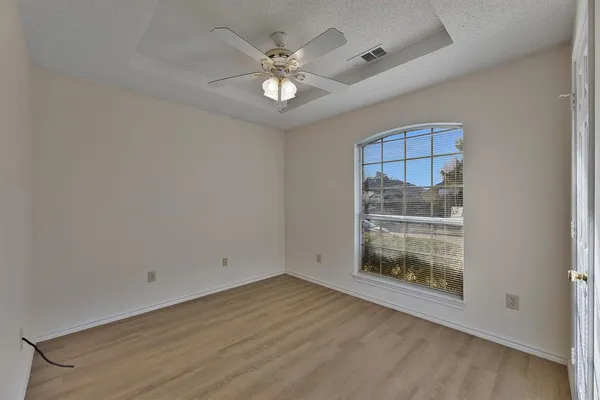 a view of wooden floor and chandelier fan in an empty room