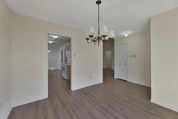 a view of a room with wooden floor and a chandelier