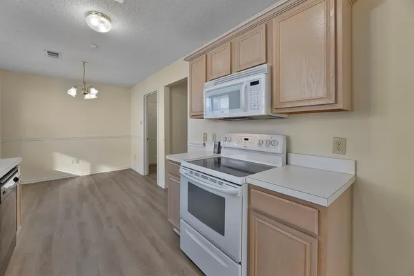 a kitchen with cabinets and steel appliances