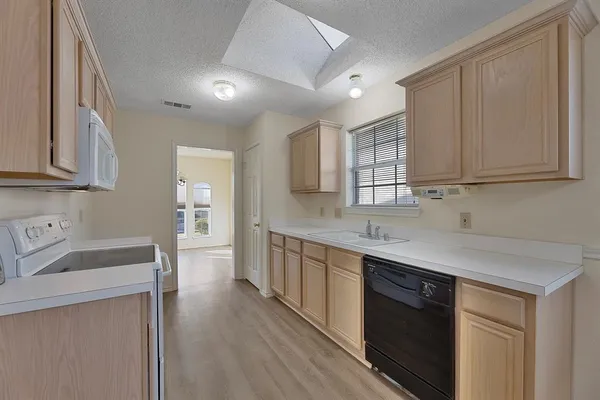 a kitchen with stainless steel appliances granite countertop a sink stove and cabinets