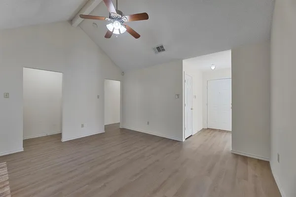 a view of empty room with wooden floor