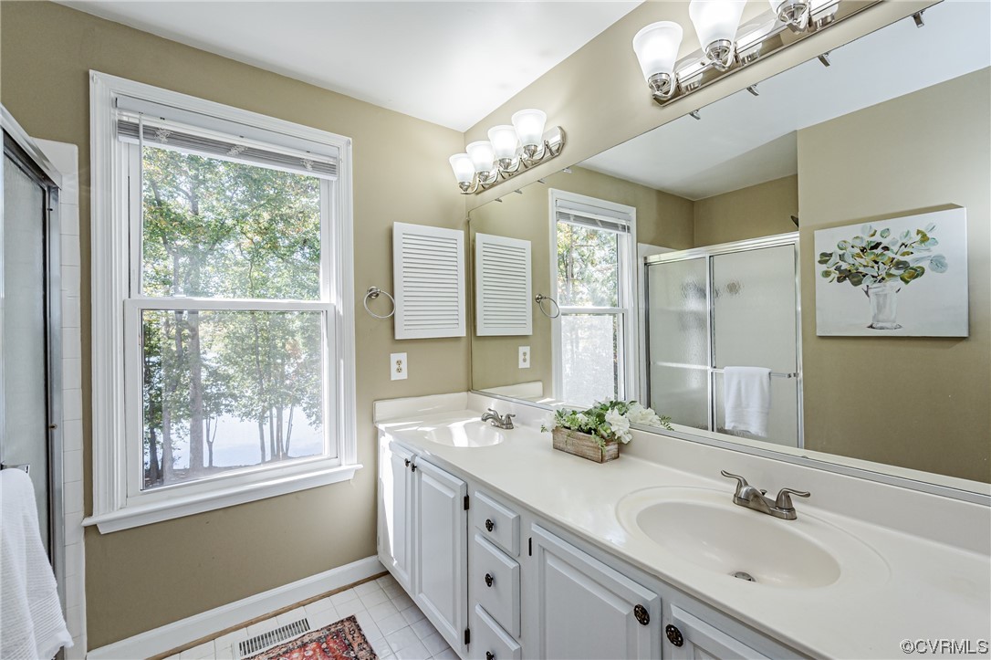 2908 Cove Ridge Trace Midlothian, VA 23112 - Photo 32 of 49 a bathroom with a double vanity sink large mirror and a shower