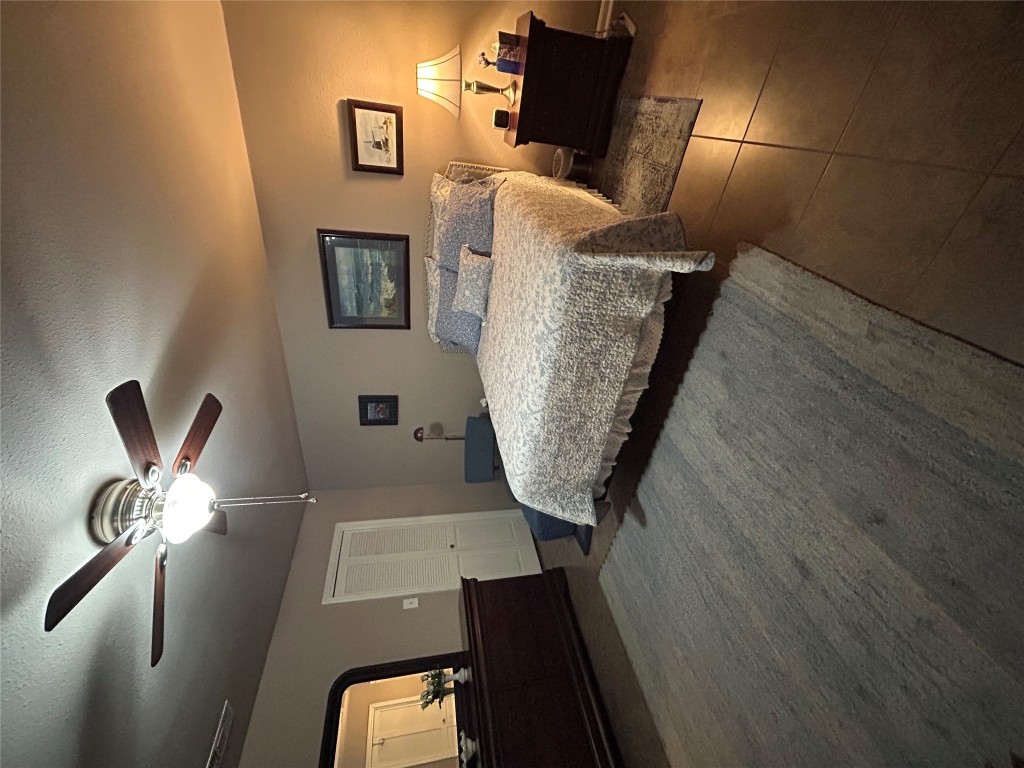 11121 Pinehurst Drive, Unit D Austin, TX 78747 - Photo 11 of 28 a bedroom with a bed and a chandelier