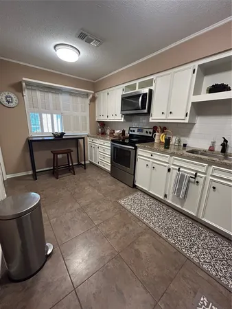 a kitchen with stainless steel appliances granite countertop a stove a sink a microwave and a refrigerator