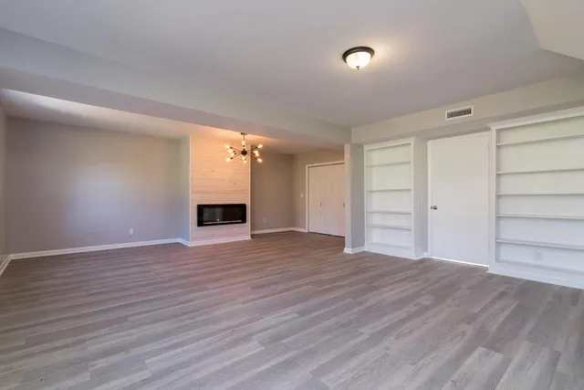 a view of an empty room with a fireplace and a window