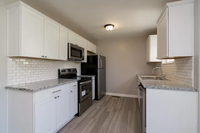 a kitchen with granite countertop wooden cabinets and a stove top oven