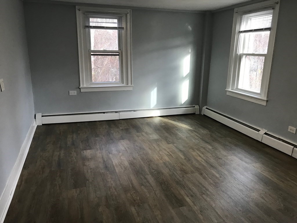176 Plymouth Street, Unit 2 Bridgewater, MA 02324 - Photo 11 of 11 an empty room with wooden floor and windows