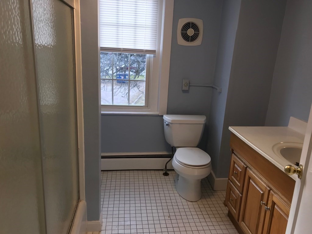 176 Plymouth Street, Unit 2 Bridgewater, MA 02324 - Photo 6 of 11 a bathroom with a toilet and a shower curtain