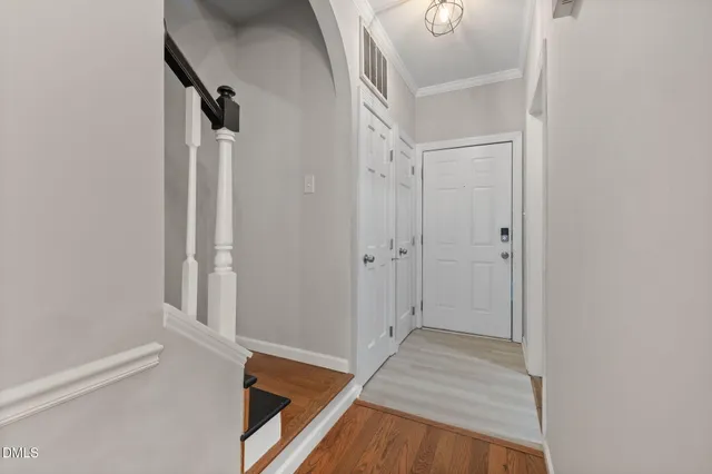 a view of a hallway with wooden floor and staircase