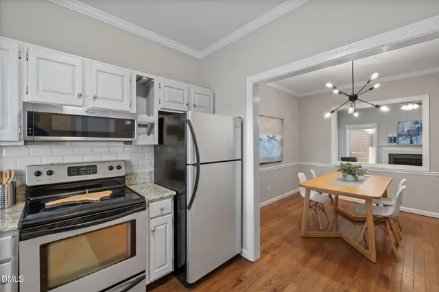 a kitchen with stainless steel appliances a stove a refrigerator and a fireplace
