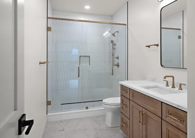 a bathroom with a granite countertop sink toilet and shower