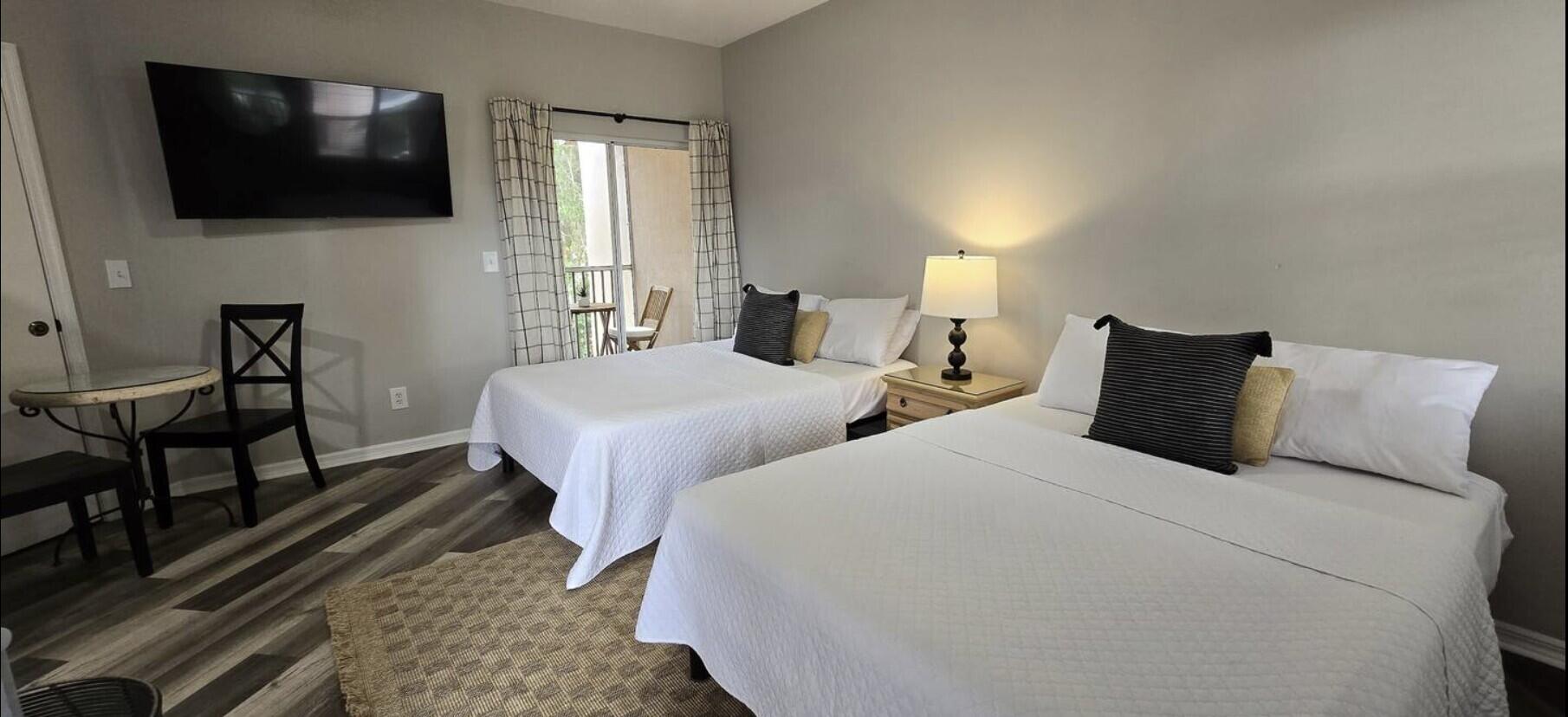 10047 Perfect Drive, Unit B Port St. Lucie, FL 34986 - Photo 2 of 13 a bedroom with two beds and a television