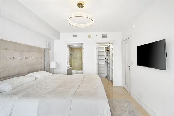 a bedroom with a bed and a flat screen tv