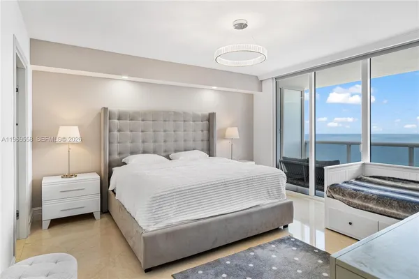 a bedroom with a large bed and a chandelier