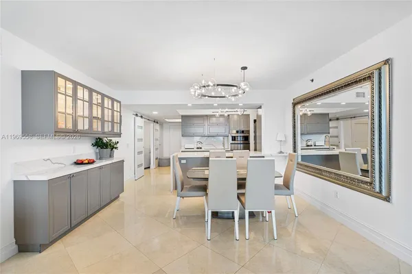 a kitchen with stainless steel appliances kitchen island granite countertop a table and chairs in it