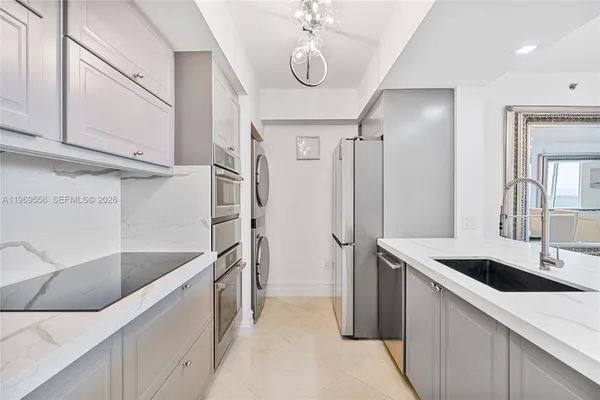 a kitchen with stainless steel appliances granite countertop a sink and a refrigerator