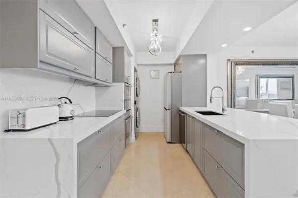 a large white kitchen with a sink and cabinets