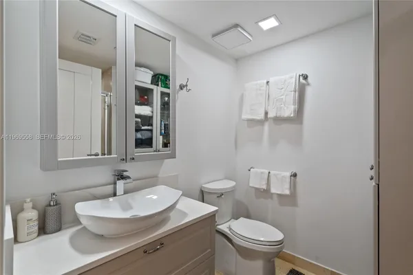 a bathroom with a sink toilet and a mirror