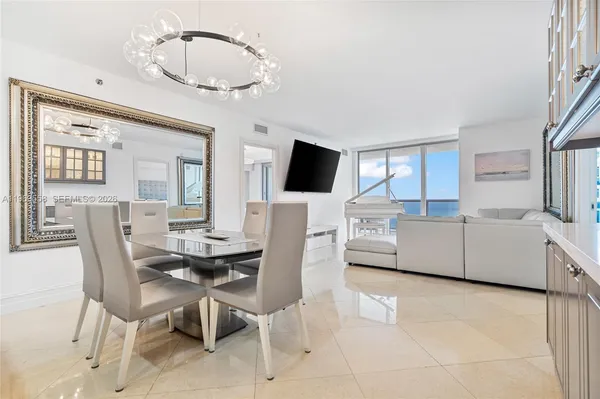 a kitchen with stainless steel appliances a table and chairs in it