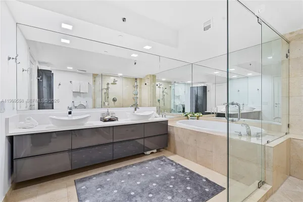 a bathroom with a tub sink shower and mirror