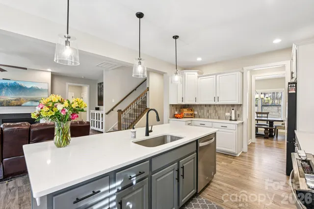 a kitchen with a sink a refrigerator and chairs
