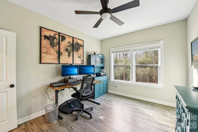 a view of a workspace with furniture and a window