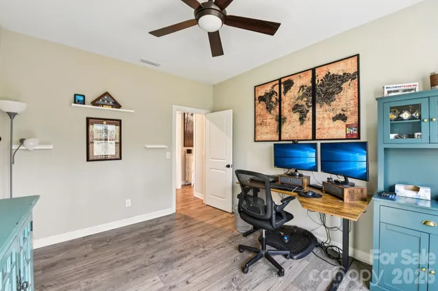 a view of a workspace with furniture and wooden floor