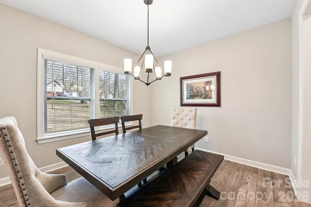 a dining room with wooden floor and chandelier