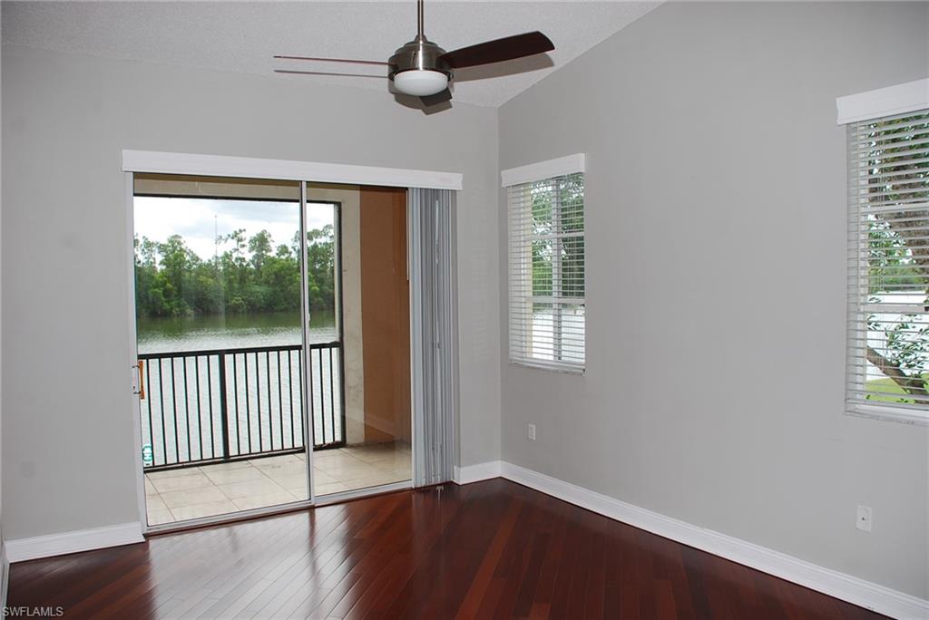1130 Reserve Way, Unit 208 Naples, FL 34105 - Photo 4 of 14 an empty room with wooden floor fan and windows