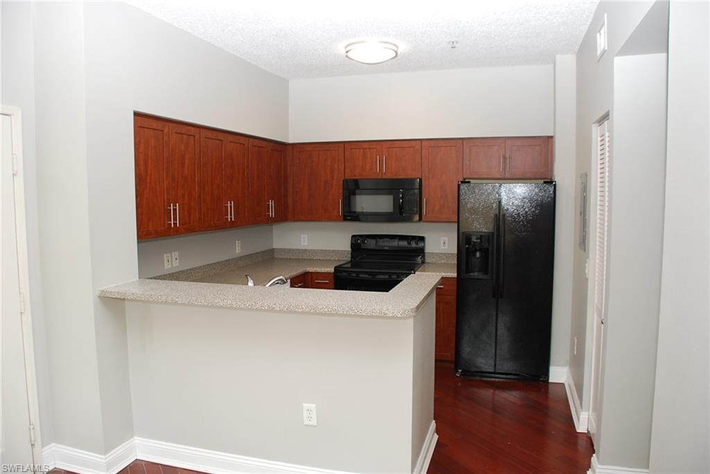 1130 Reserve Way, Unit 208 Naples, FL 34105 - Photo 6 of 14 a kitchen with a refrigerator and a stove