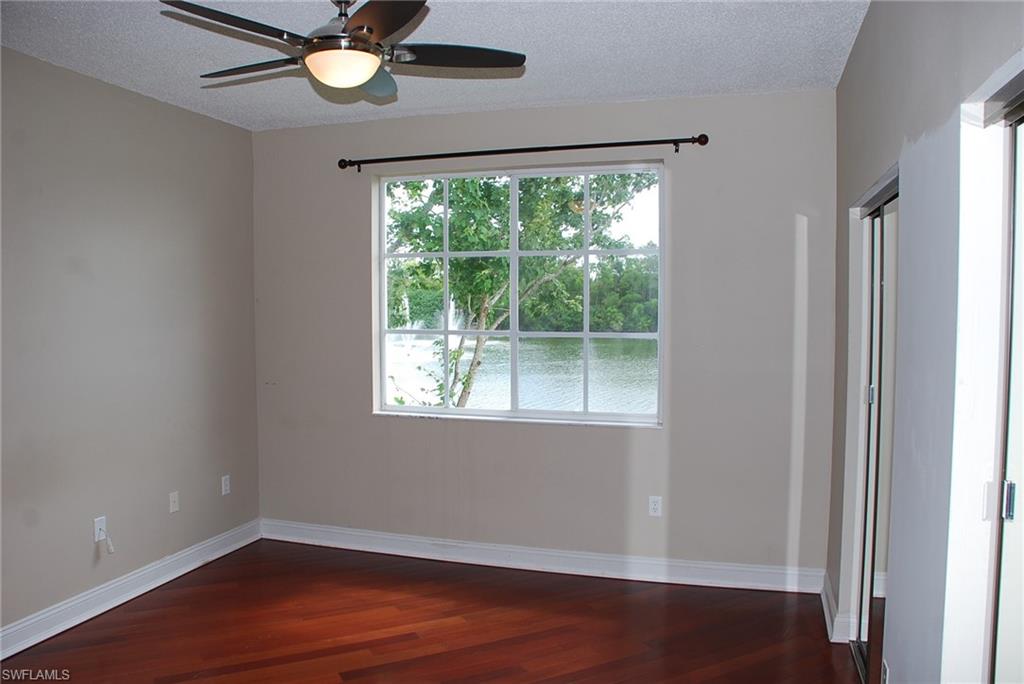 1130 Reserve Way, Unit 208 Naples, FL 34105 - Photo 7 of 14 a view of an empty room with wooden floor and a window
