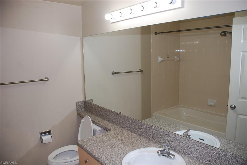 1130 Reserve Way, Unit 208 Naples, FL 34105 - Photo 8 of 14 a bathroom with a granite countertop sink mirror and toilet